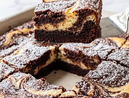 Tortul de ciocolată cu umplutură de cheesecake este un desert excepțional care îmbină aroma intensă de cacao cu o cremă catifelată.