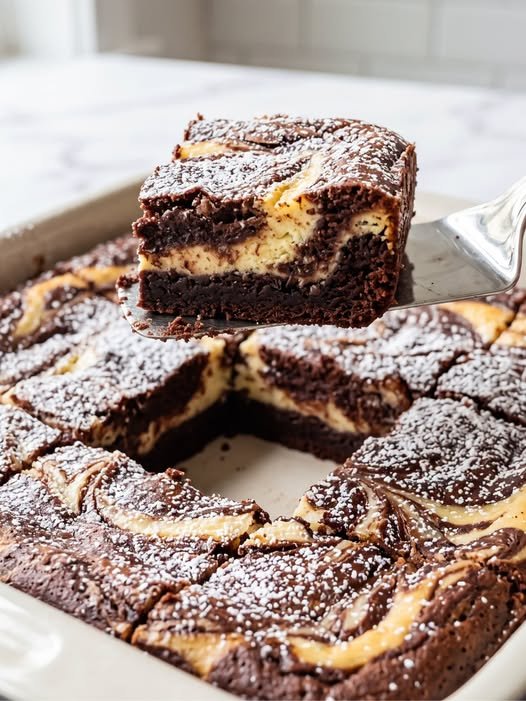 Tortul de ciocolată cu umplutură de cheesecake este un desert excepțional care îmbină aroma intensă de cacao cu o cremă catifelată.